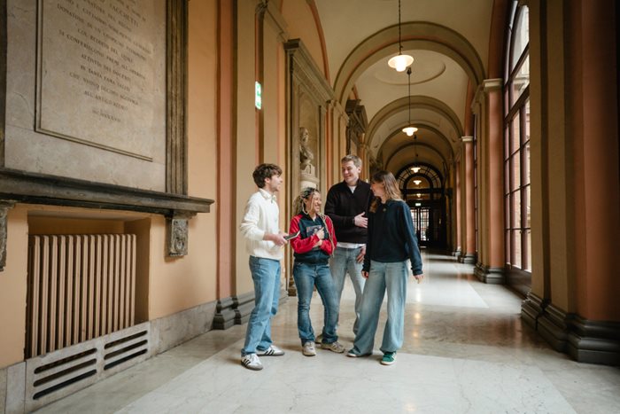 Group of two girls and two boys chatting in Palazzo Poggi