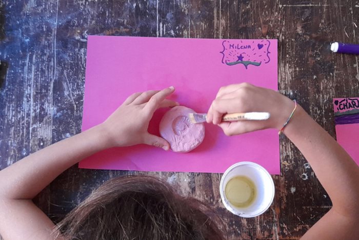 Photo of a little girl painting a plaster cast of a fossil during an educational activity
