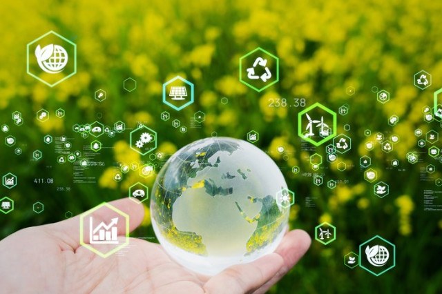 A hand is holding a transparent sphere representing the planet Earth