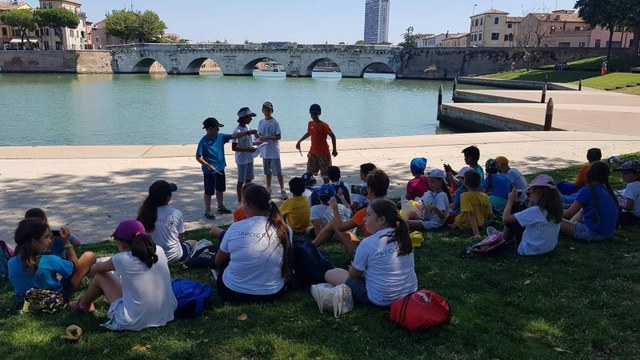 Bambini che partecipano ad attività di educazione all'aria aperta presso la Piazza sull'acqua di Rimini al ponte di Tiberio