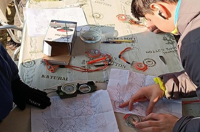 Bambini che si orientano davanti ad una mappa all'aperto