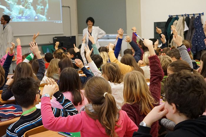 Classe di bambini con le mani alzate
