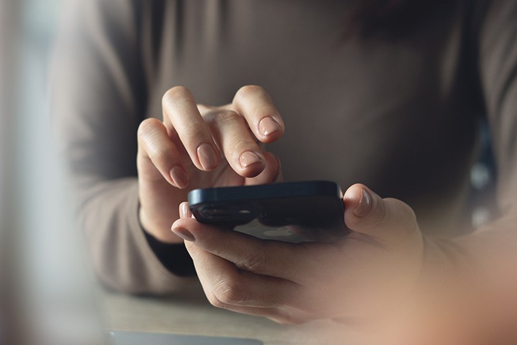 Mani che digitano su un telefonino