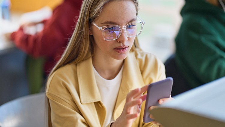 Studentessa che cerca cose sul cellulare