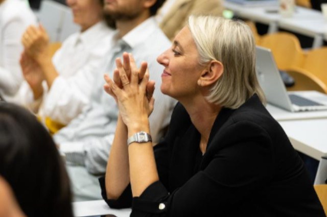 Donna di mezza età sui banchi di un'aula universitaria
