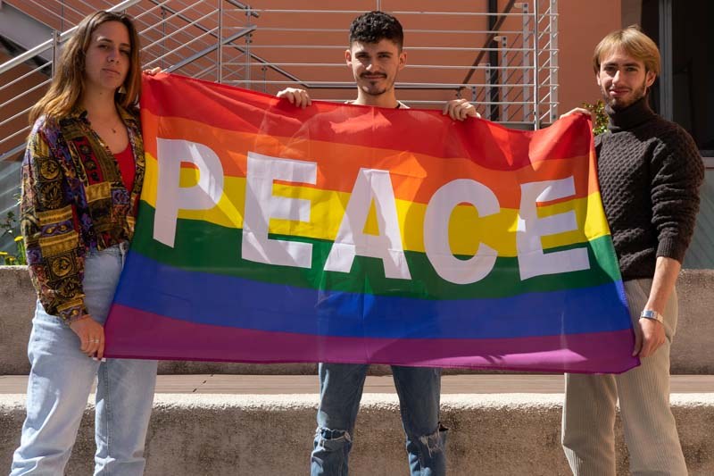 Studenti e studentesse che mostrano la bandiera della pace