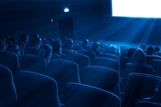 Spettatori e spettatrici in un cinema durante una proiezione