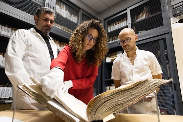 Ricercatori con un manoscritto antico