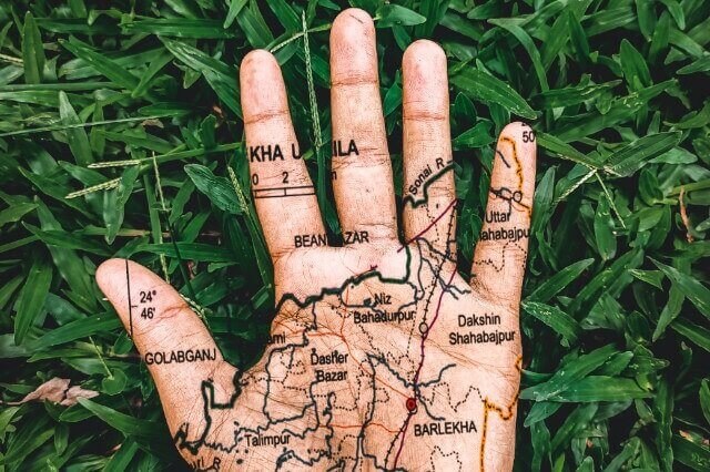Immagine grafica di una mano aperta con una mappa disegnata sopra