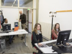 Laboratorio di psicologia con tre persone sedute al computer ed una in piedi